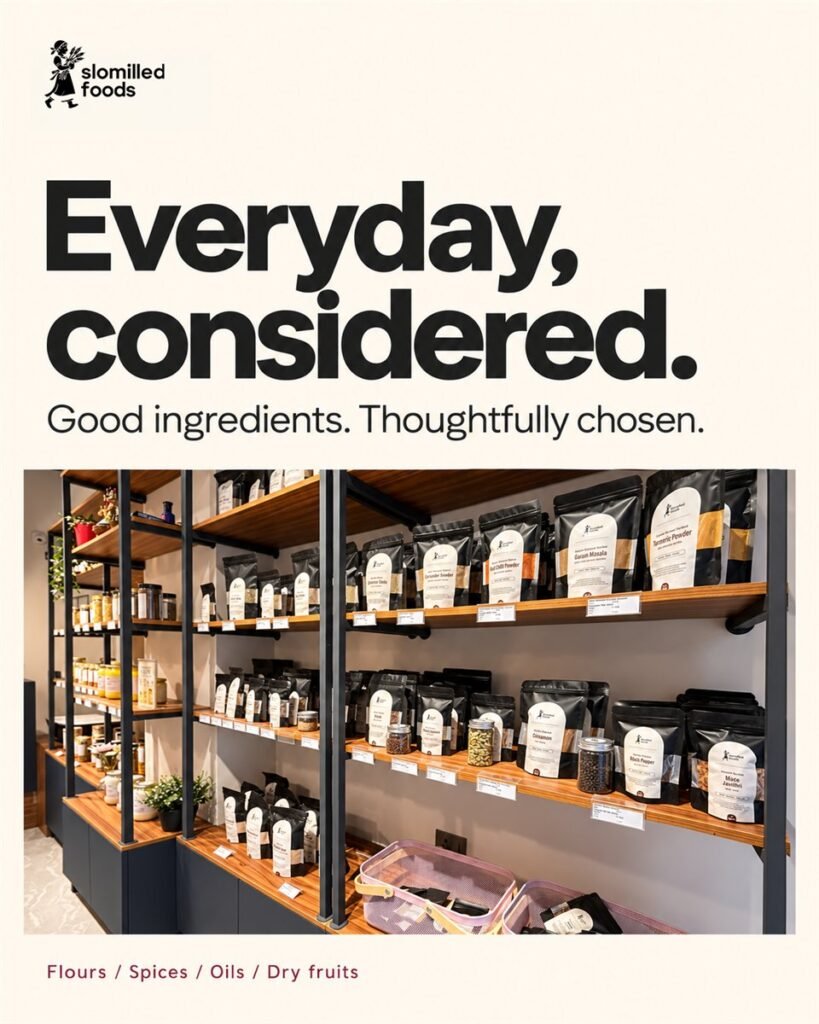 Slomilled Foods poster: “Everyday, considered. Good ingredients. Thoughtfully chosen.” Shelves of packed flours, spices, oils and dry fruits.